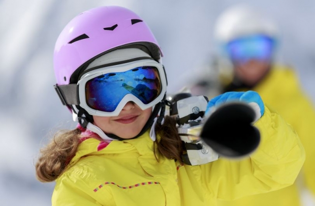 nina llevando el material para esquiar